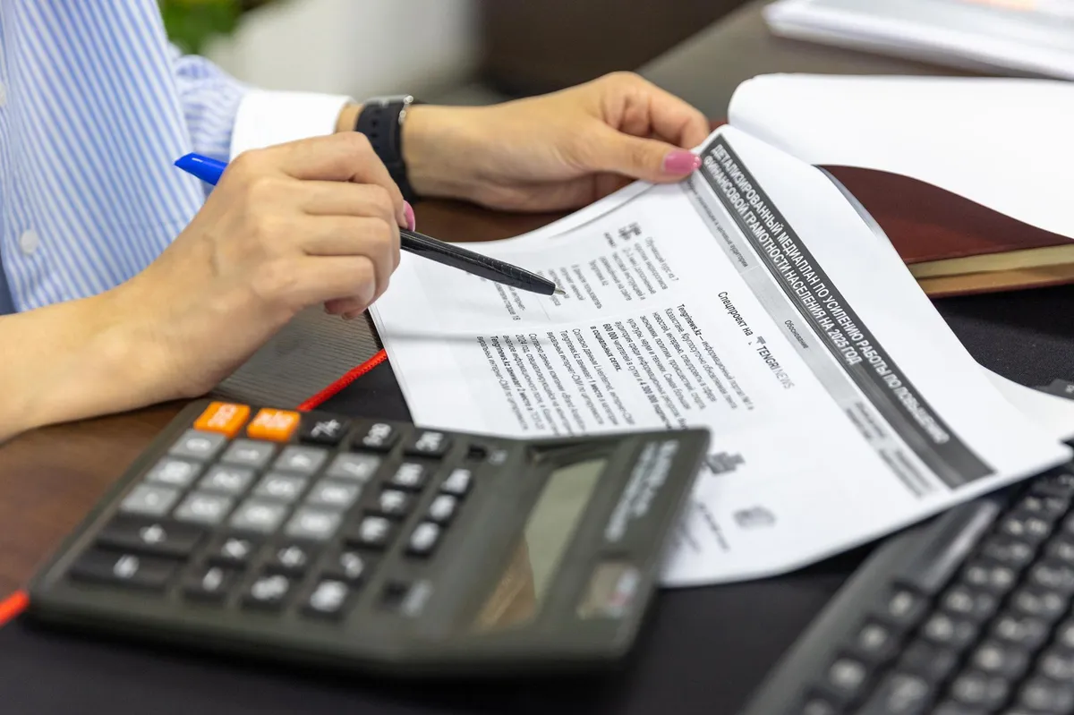 Contadora trabajando con documentos y calculadora en su escritorio